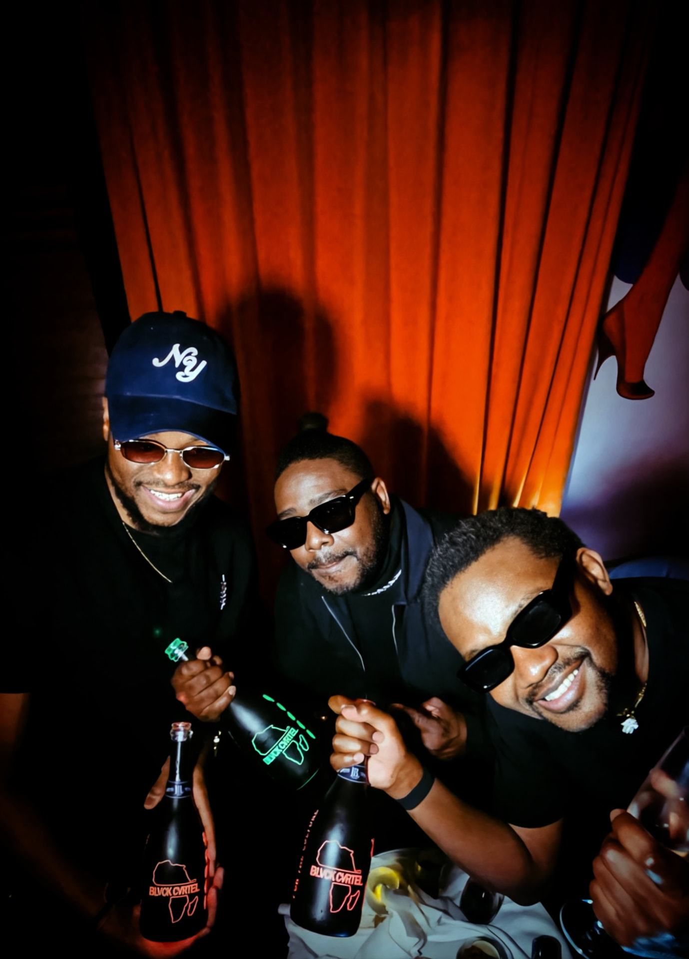 Trio célébrant avec des bouteilles BLVCK CVRTEL